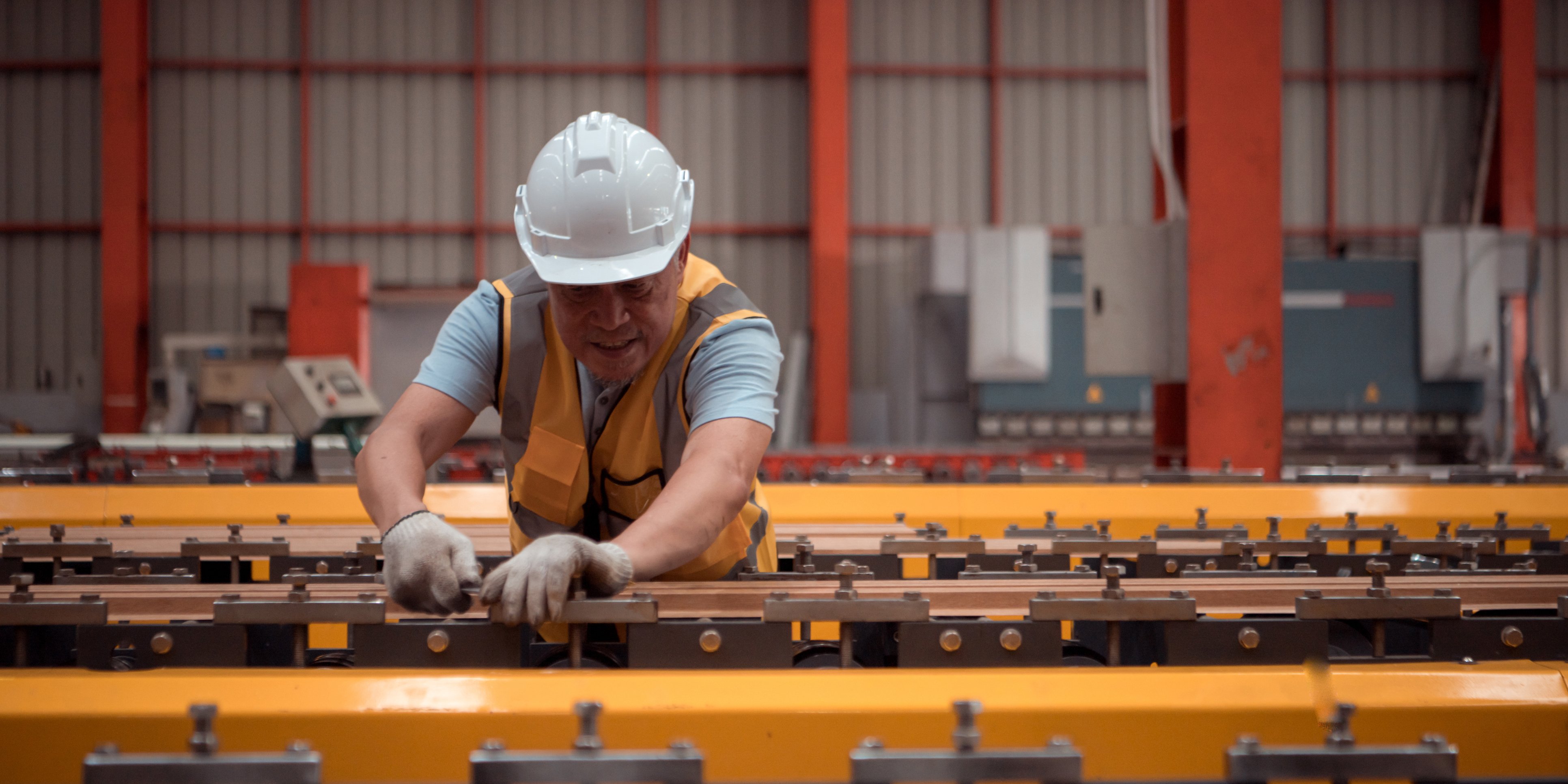 Worker leaning over machine